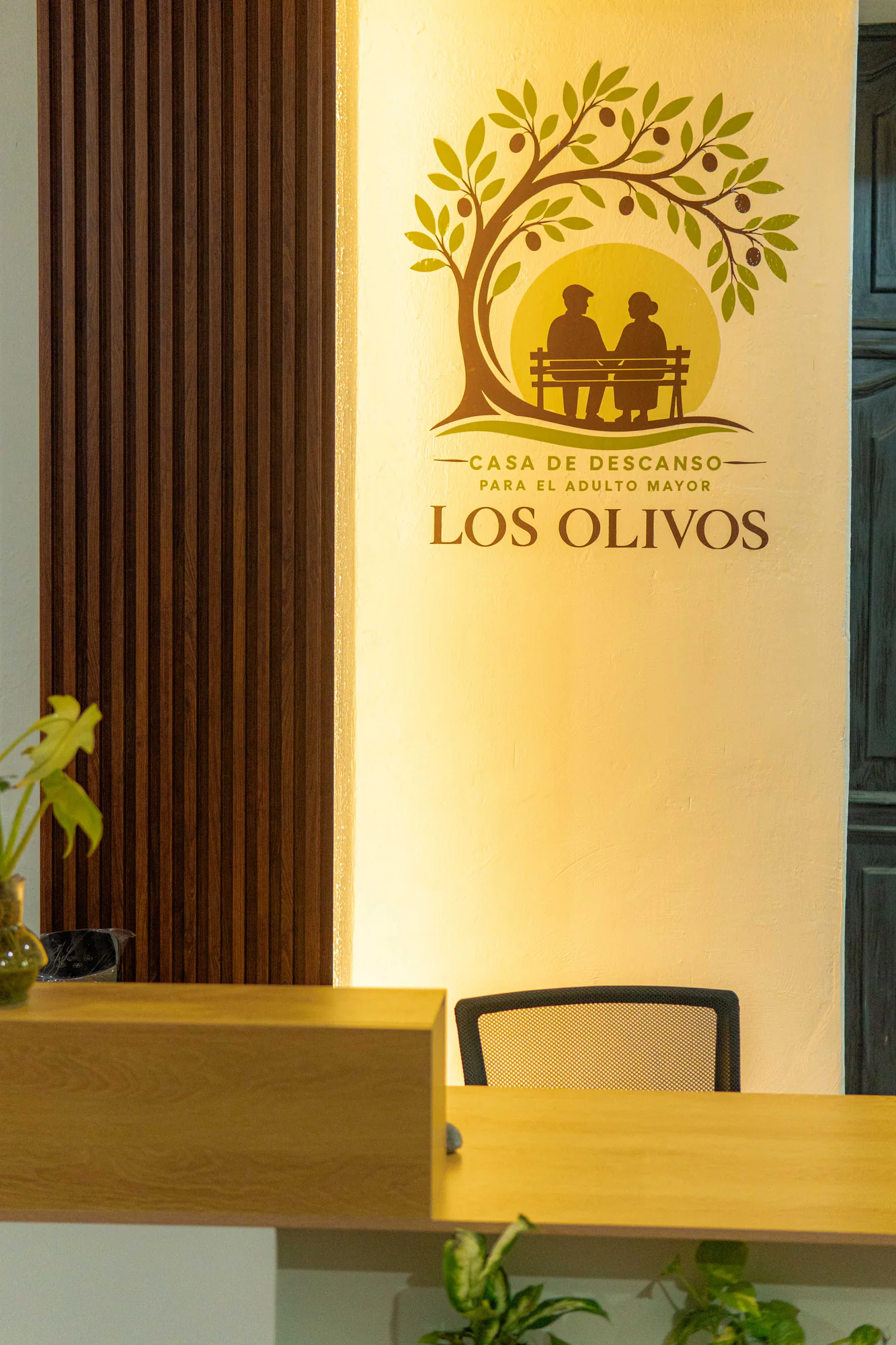 Recepción de Los Olivos con el logotipo de la casa en el muro